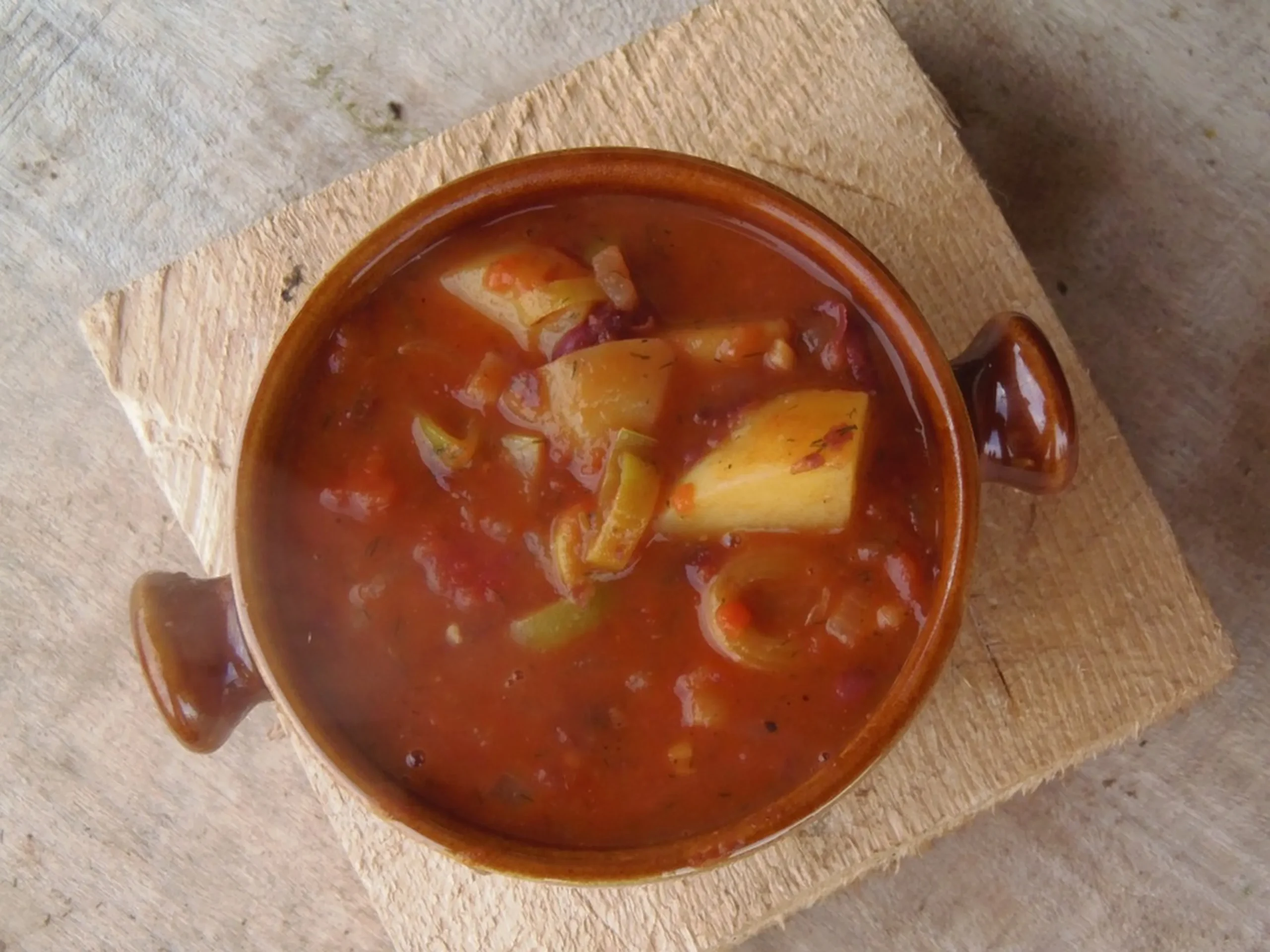 A medio camino entre el estofado y la sopa, suele elaborarse a partir de carne y vegetales como patatas, zanahorias o pimientos, sin que falte el clásico pimentón.